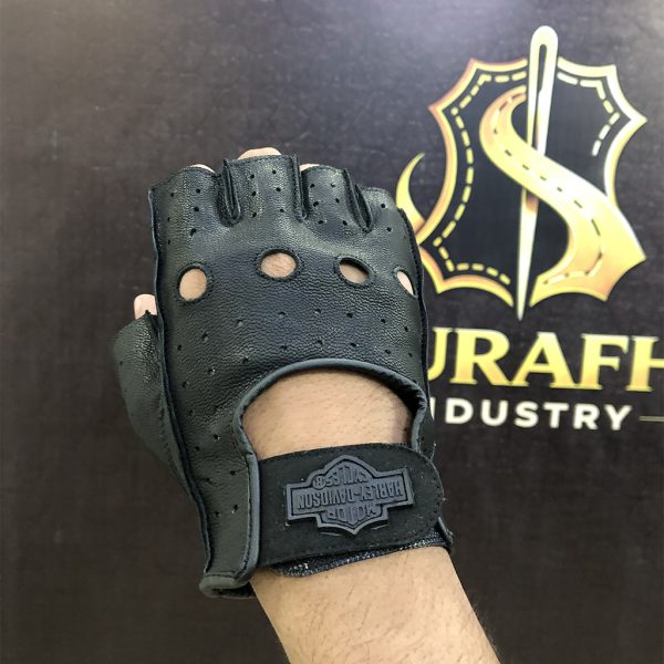 Back of hand view of a custom black leather fingerless motorcycle glove showcasing knuckle cutouts, a perforated pattern, and a custom private label rubber wrist strap modification against a Surafh Industry backdrop.