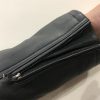 Close-up view of the adjustable zippered sleeve cuff on a wholesale men's leather jacket, detailing the durable metallic hardware and seam finish.