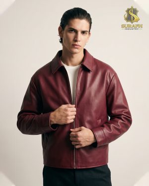 Front lifestyle studio view of a model showcasing a custom men's burgundy leather harrington jacket with a full zip front and turn-down collar under the Surafh Industry branding logo.