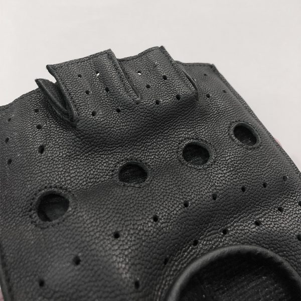 Macro close-up shot of the back casing on a wholesale leather tactical glove detailing the precise industrial multi-hole perforation and clean finger slot edge finishes.