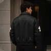 Model wearing black Cross Patch Leather Varsity Jacket - back view lifestyle shot